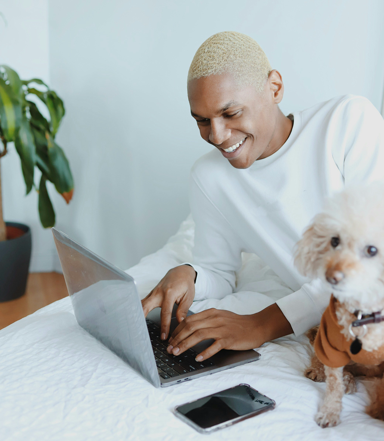 Freelancer working on a laptop with a dog beside him